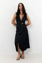 Vestido midi marrón con escote en V, sin mangas y detalle de nudo con aro dorado en la cintura.