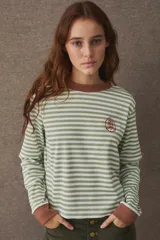 Remera de manga larga con diseño de rayas horizontales en color verde y blanco. Presenta cuello redondo y puños en color marrón a contratono, con un pequeño escudo bordado en el pecho.