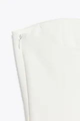 Top color amarillo claro, sin mangas y con escote recto. El bajo tiene un acabado peplum.