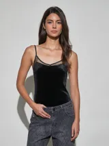 Body negro confeccionado en terciopelo, de corte ajustado, con tirantes finos y detalles de encaje transparente en el escote.