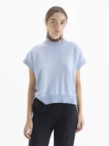 Chaleco de tejido de punto en color celeste, con cuello redondo y mangas cortas con terminación en rib. Presenta un diseño holgado con aberturas laterales en el ruedo y un pequeño bordado decorativo en la parte inferior.