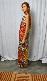 Vestido largo con estampado multicolor, cuello alto abotonado en la parte posterior y tajo lateral.