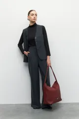 Bolso tipo shopper de símil cuero trenzado color rojo oscuro/bordó, con asas fijas centrales y gran compartimiento interior con tres bolsillos adicionales.