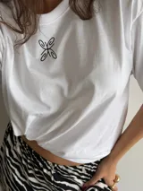 Remerón de algodón color celeste, de corte oversize y mangas cortas, con pequeño diseño estampado en el centro del pecho.