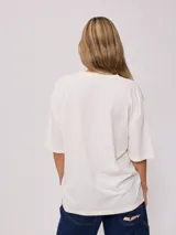 Remera color crema con estampado de estilo surf en el frente. Corte oversized.