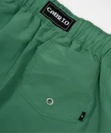 Short de baño verde con estampado de símbolos de yin y yang en blanco y negro. Tiene cintura elástica ajustable con cordón, bolsillos laterales y traseros, y logo bordado.