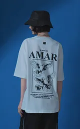 Remera blanca de corte oversize con cuello redondo y manga corta. Presenta una estampa gráfica en la espalda con diseño de palomas, flores y texto en español.
