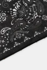 Pañuelo bandana de algodón negro con estampado paisley en blanco y detalles de abalorios y flores en crochet en las esquinas.