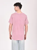 Remera color beige con estampa rectangular con diseño abstracto en tonos marrones y texto.