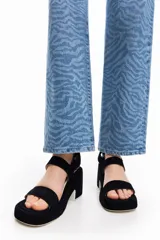 Sandalias negras con plataforma y taco ancho, con dos tiras horizontales sobre el empeine y una tira ajustable con velcro en el tobillo.