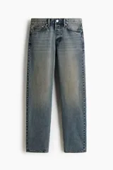 Pantalón jean de cinco bolsillos en denim de algodón rígido, con pierna recta apenas holgada y corte estándar. Cuenta con cintura clásica y cierre de botones.