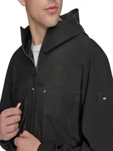 Campera impermeable negra de Tommy Hilfiger, con capucha, cierre de cremallera, dos bolsillos laterales con cierre y logo engomado en la manga.