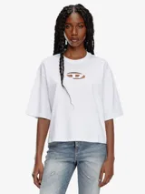 Camiseta blanca de algodón orgánico con corte oversize y forma cuadrada. Presenta un logotipo moderno con efecto 'peekaboo' en el pecho, donde un parche de la 'D' ovalada cortada a láser deja ver la piel.