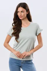 Remera de algodón color verde menta, con escote redondo y mangas corta con detalles de volados sutiles en los puños.