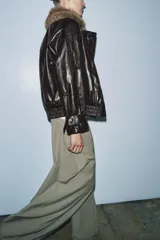 Chaqueta de efecto cuero con acabado brillante, cuello de solapa con aplicación de pelo sintético extraíble, cierre frontal cruzado con botones, mangas largas con puños ajustables y bajo elástico. Cuenta con forro interior acolchado.