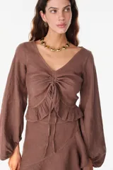 Top de lino italiano color beige, con escote en V, mangas abullonadas y cordón ajustable en el centro del frente.