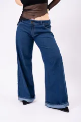 Pantalón de jean estilo wide leg en color azul oscuro, con talle medio y ruedo con doblez ancho.