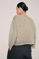 Sweater de punto fino color beige con finas rayas horizontales negras, cuello redondo y manga larga.