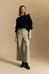 Sweater negro de manga larga, tejido suave y caída liviana, con volados en el delantero y mangas. Silueta recta.