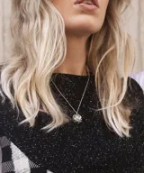 Collar plateado con dije esférico texturizado con incrustaciones de gemas de colores.