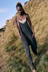 Enterizo de algodón y spandex color negro lavado, de corte holgado con entrepierna caída y tirantes finos. Presenta bolsillos laterales amplios.