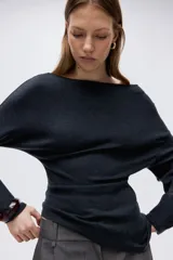 Top de punto interlock pesado con escote bote, manga larga con hombros caídos y bajo asimétrico.