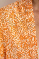 Kimono oversize color naranja con estampado floral blanco, mangas 3/4 y confeccionado en rayón.