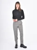 Pantalon de vestir de corte recto y tiro medio, con estampado de cuadros en tonos grises. Cuenta con bolsillos laterales y cierre frontal con botón y cremallera.