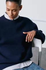 Falda midi de tiro medio confeccionada en denim con efecto lavado. Presenta cintura con trabillas, cierre frontal con cremallera, botón y gancho metálico, y una abertura en el bajo.