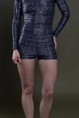 Short de lycra estampado con diseño gráfico de letras y líneas en tonos oscuros, de corte ajustado y tiro medio.