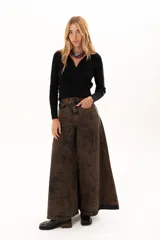 Pantalón de jean de tiro alto con corte wide leg y diseño de paneles verticales. Presenta un acabado lavado con efecto desgastado en tono chocolate, bolsillos funcionales y cierre frontal con botón metálico.