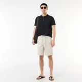 Bermuda chino color gris claro, de corte recto, con cintura elástica ajustable mediante cordón y bolsillos laterales.