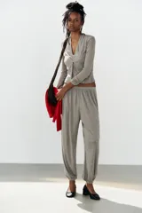 Top de punto efecto doble color gris melange, con diseño de cuello en pico, tirantes tipo halter interiores y cierre frontal con botones. Cuenta con mangas largas.