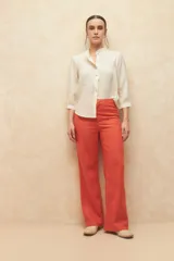 Pantalón de lino color verde, de tiro alto, con bolsillos en el frente y atrás, y corte recto.