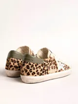Zapatillas Golden Goose modelo Super-Star, con estampado animal print de leopardo, estrella plateada en el lateral y detalle verde en el talón.