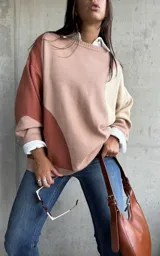 Sweater de punto con diseño color block en tonos tierra, cuello redondo y mangas largas con puños acanalados.