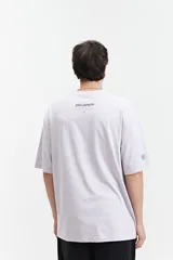 Remera negra de manga corta con corte oversize y cuello redondo. Presenta un estampado pequeño en la espalda con texto en naranja y blanco que dice "Free Spirits Freedom & Waves All Day / Every Day".