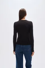 Remera verde esmeralda de manga larga, corte ajustado y cuello redondo.