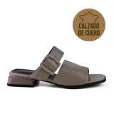 Sandalia de cuero color visón, con tira ancha sobre el empeine y tira con hebilla ajustable en el tobillo. Taco bajo cuadrado.
