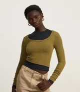 Blusa de manga larga confeccionada en tejido rib de viscosa con textura acanalada. Presenta un diseño corto con escote redondo profundo y ajuste al cuerpo.