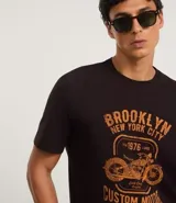 Remera negra de algodón con cuello redondo y mangas cortas. Estampa frontal con diseño de moto y texto "Brooklyn New York City 1976 Custom Motor Vintage Co.".