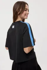 Remera blanca de manga corta, con cuello redondo, calce relajado y estampado frontal con motivos gráficos de soles y símbolos marinos en tonos rosados y bordo, además de líneas horizontales.