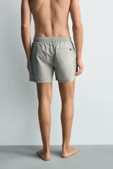 Short de baño confeccionado en tejido técnico con patrón de rayas verticales en tonos azul marino y blanco, con cintura elástica ajustable mediante cordón y bolsillos laterales.