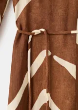 Vestido midi con estampado animal print tipo cebra en tonos marrón y blanco, de corte recto, con escote en V, mangas tres cuartos y tajo delantero en la falda. Incluye un cinturón fino ajustable.