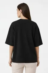 Remera de algodón color blanco, de corte holgado y diseño minimalista con cuello redondo y mangas cortas amplias.