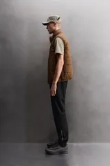 Pantalón de jogging negro confeccionado en tejido técnico ligero y elástico, corte slim fit, con cintura elástica ajustable con cordón, bolsillos laterales y trasero con cierre de cremallera, bandas reflectantes en las piernas y bajos ajustables con cremallera.