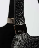 Bolso de hombro azul marino de cuero graneado con logo grabado en el centro.
