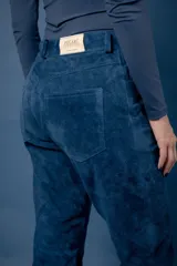 Pantalón de cuero ovino italiano color crema, de corte recto con tajos laterales en el ruedo.