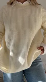 Sweater de punto grueso color crema, con cuello redondo y diseño de calce relajado.