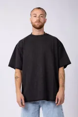 Remeron de algodón rústico con corte oversize y fit relajado. Presenta cuello redondo, mangas cortas y costuras al corte en los bordes, con una textura pesada y estructurada.